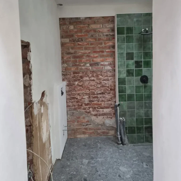 Kleinstes Haus Deutschlands: Duschbereich mit grünen Fliesen vor historischer Backsteinwand
