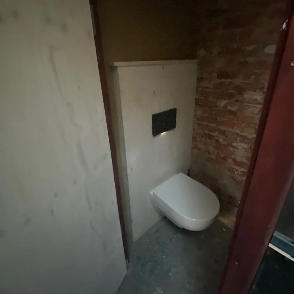 Kleinstes Haus Deutschlands: WC im Rohbau mit Holzplatten und Backsteinwand