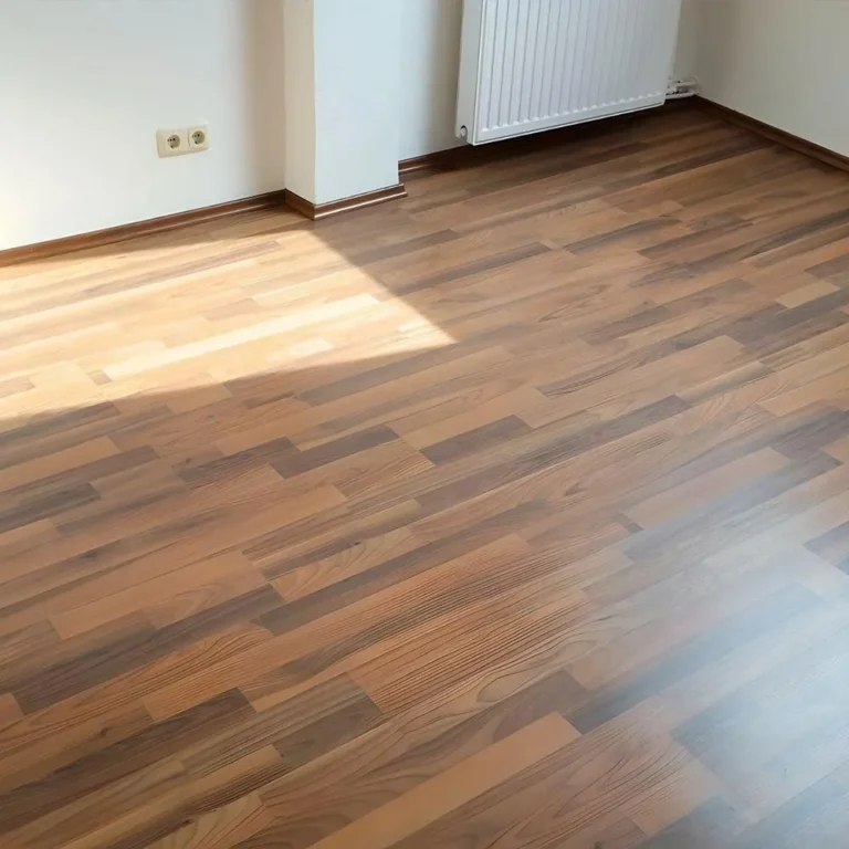Leerer Wohnraum in Bremen mit Laminatboden in rötlicher Holzoptik und Fußleisten