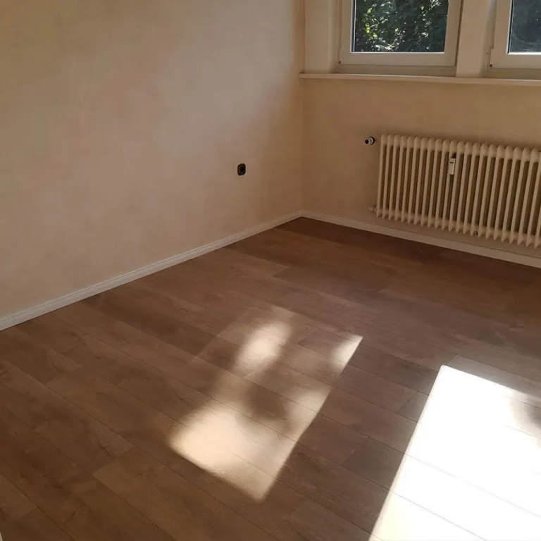 Wohnraum in Bremen mit neu verlegtem Laminatboden in Holzoptik im Sonnenlicht
