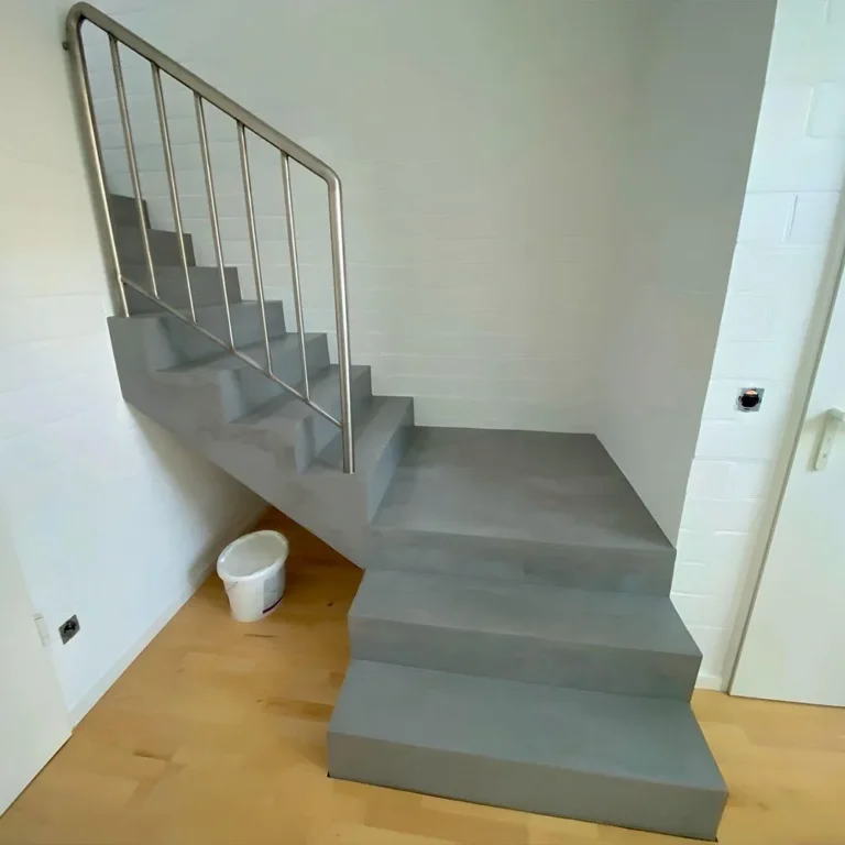 Graue Mikrozement-Treppe mit Edelstahlgeländer