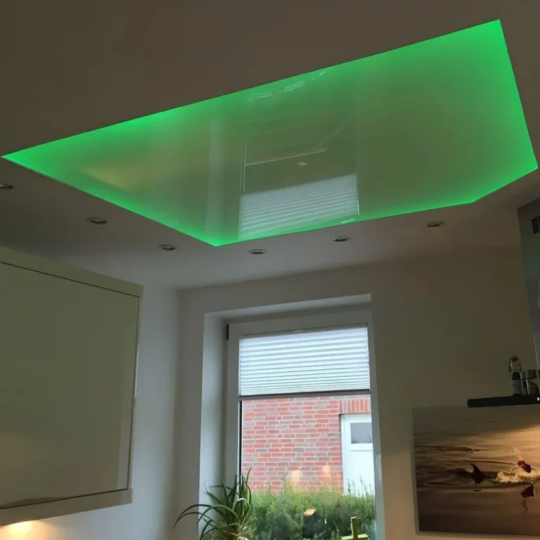 Deckenfeld mit grün leuchtender indirekter RGB-LED-Beleuchtung und Einbaustrahlern
