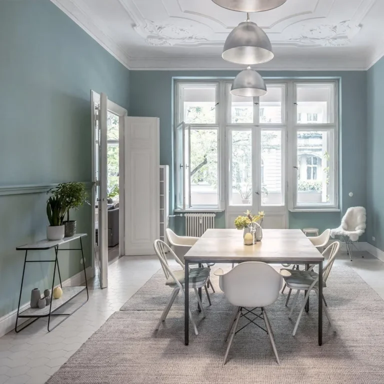 Esszimmer im denkmalgeschützten Altbremer Haus mit restauriertem Deckenstuck und blau gestrichenen Wänden