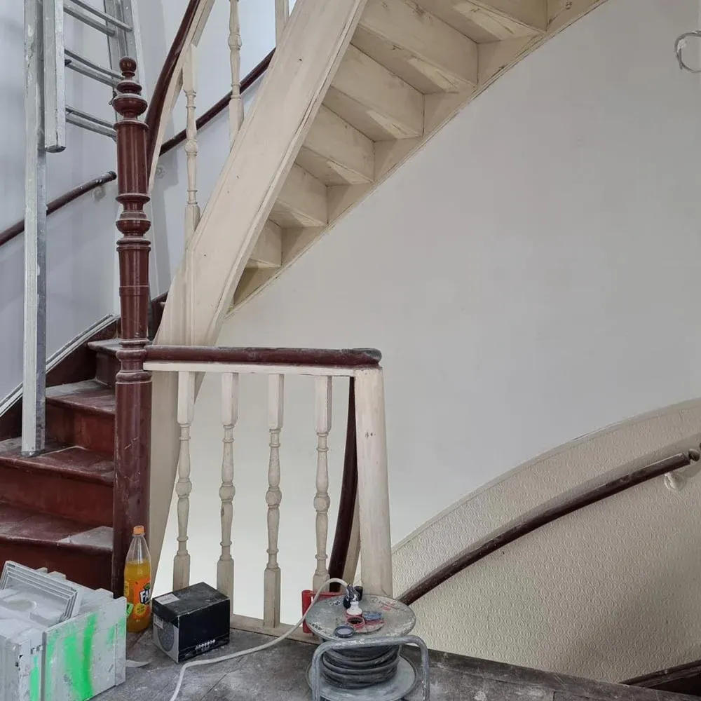 Gewendelte Holztreppe von oben nach der Sanierung mit heller, gleichmäßig lackierter Holzoberfläche