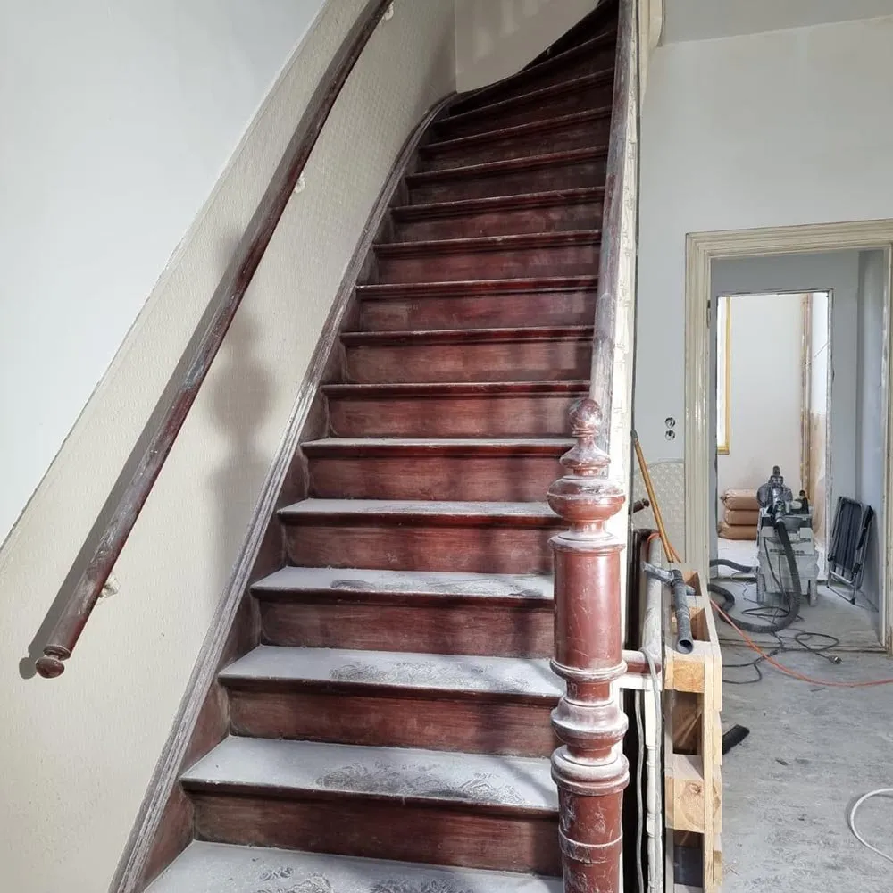 Rund 100 Jahre alte Holztreppe in Bremen-Neustadt vor der Sanierung mit dunklen, abgenutzten Lackschichten